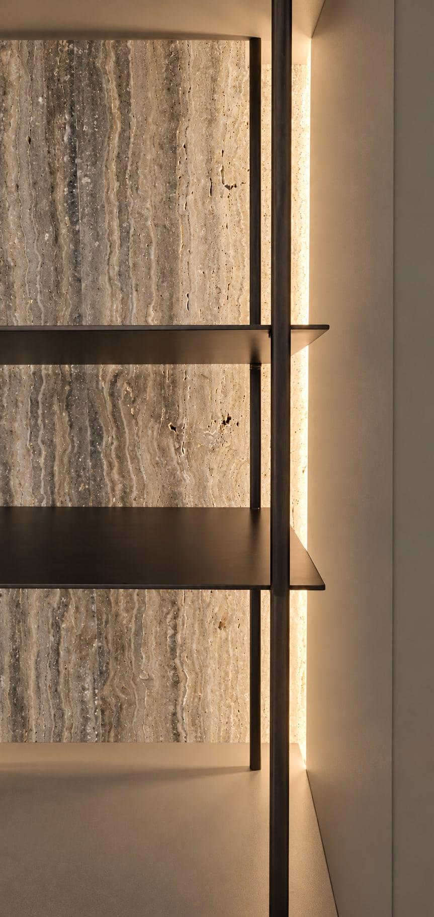 Bronze shelves on slim uprights against backlit travertine, with a light strip set into the side of the niche
