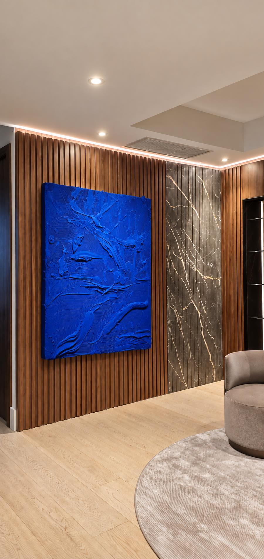 Blue textured artwork on walnut slats beside a marble panel
