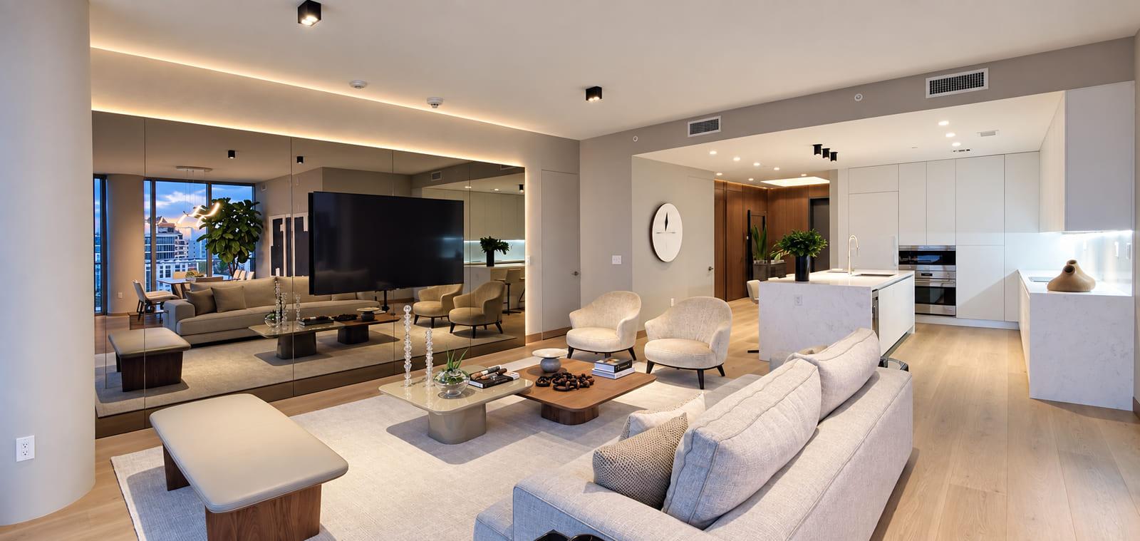 The finished living room with the mirrored wall on the left and the kitchen beyond